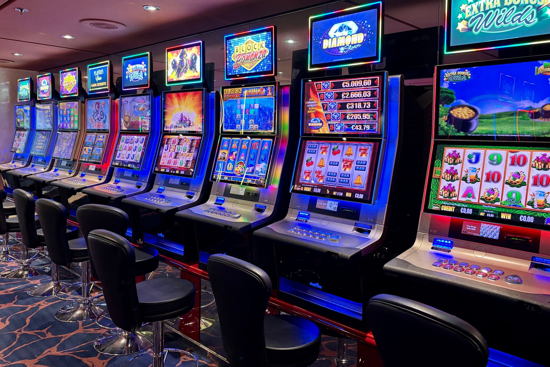 Bright casino slot machines with colorful displays and no people present.