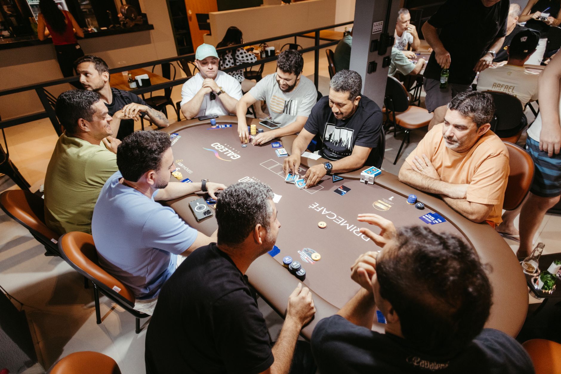 Group of men engaged in a poker game at an indoor setting, showcasing social interaction.
